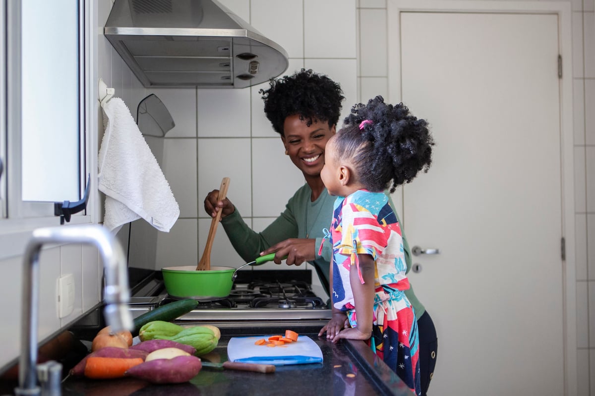A mother and her daughter cooking healthy food together at home