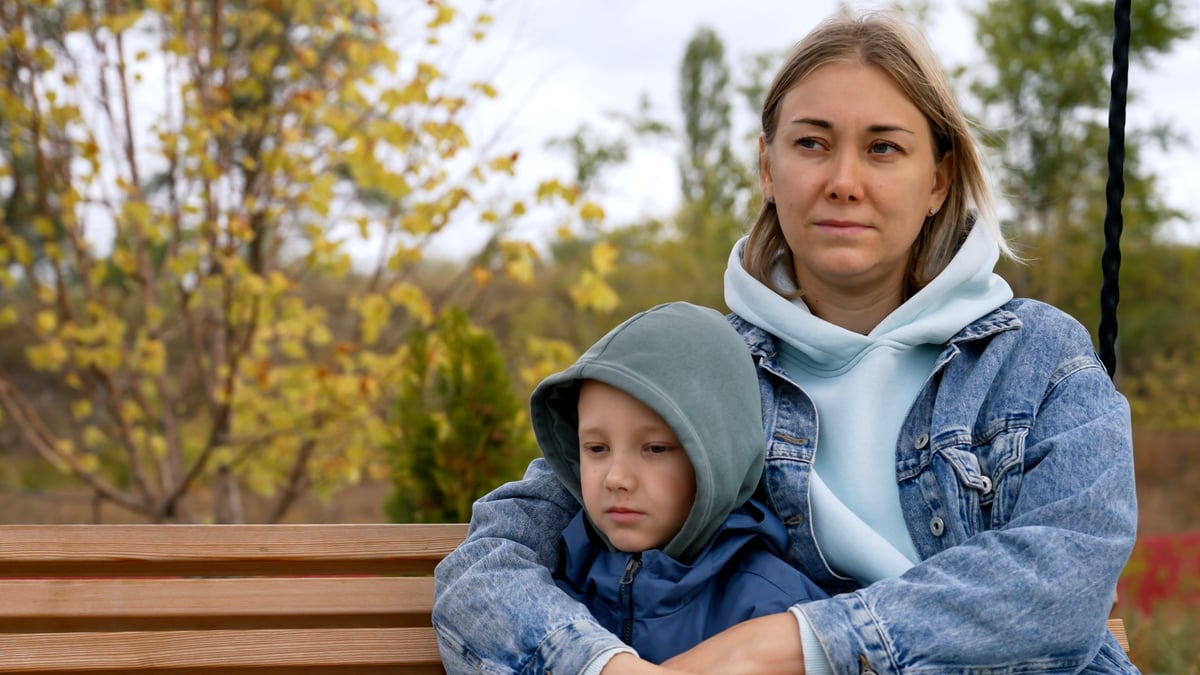 A mother and her son enjoying a relaxing weekend together on a swing in a peaceful park